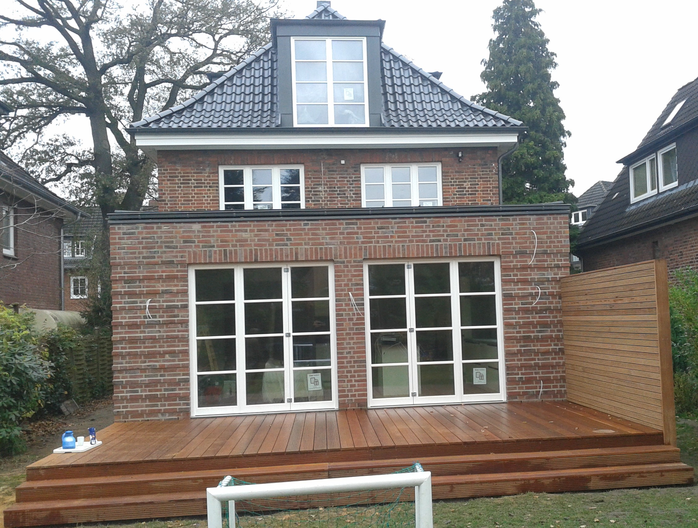 Dachneubau mit verklinkertem Holzrahmenanbau und Bankgirai-Terrasse